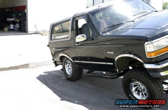 Black Ford Bronco, side view, showing the front fender and door. Has a 'Bronco' badge