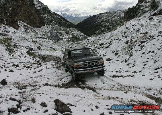 1994 Ford Bronco driving on a snowy mountain road