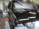 1987 Ford Bronco - A black truck is being prepped for painting, with plastic sheeting covering the windshield and hood.