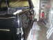 1987 Ford Bronco - The body of a black 1987 Ford Bronco is shown in a garage, likely undergoing paintwork or restoration.