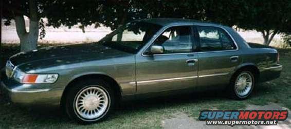 Green 2002 Mercury Grand Marquis sedan parked under trees