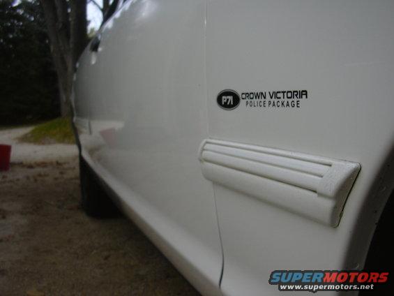 White police car door with "Crown Victoria Police Package" badge and side molding