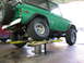 1975 Ford Bronco - A green 1975 Ford Bronco is shown on a car lift, with its rear spare tire mounted.