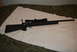 1991 Ford Bronco - A rifle with a scope is shown from the side, resting on a white cloth.