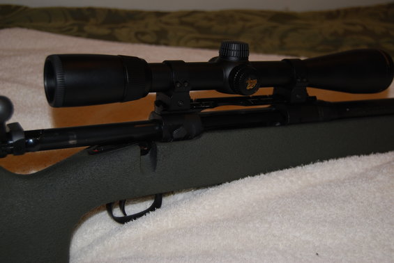 Rifle with a black scope mounted on top