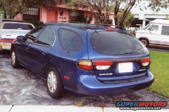 Blue station wagon, rear 3/4 view, parked on asphalt
