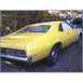 1971 Mercury Cyclone - A yellow coupe is parked outdoors next to another vehicle, showing its rear end.