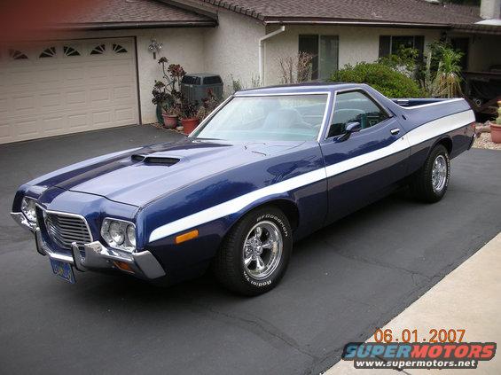 Blue and white 1972 Ford Ranchero with chrome wheels and racing stripes parked in a driveway