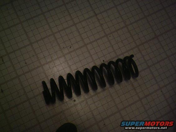 Black coil spring on a grid floor