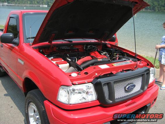Red 2004 Ford Ranger with hood open, showing engine and aftermarket grille