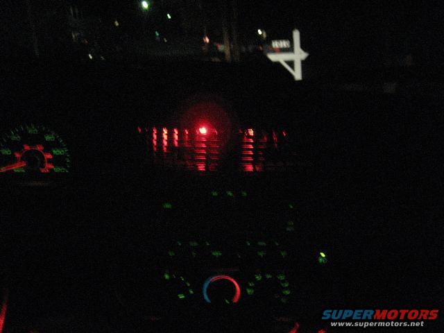 dashboard with illuminated gauges and red warning light