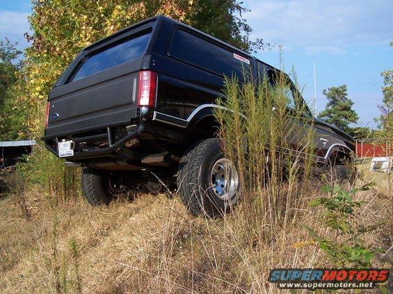 Black Ford Bronco parked on grassy incline, aftermarket rear bumper visible