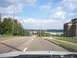 1970 Ford Ranchero - View from a vehicle driving down a road towards a distant body of water under a partly cloudy sky.