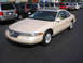 1995 Ford Thunderbird - Tan Lincoln Mark VIII coupe parked in a lot with other vehicles behind it.