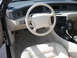 1995 Ford Thunderbird - The interior of a car shows white leather seats, a steering wheel, and a car phone, with a watermark from Supermotors.net.