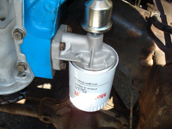 Engine oil filter labeled FL-1A, attached to a blue engine block