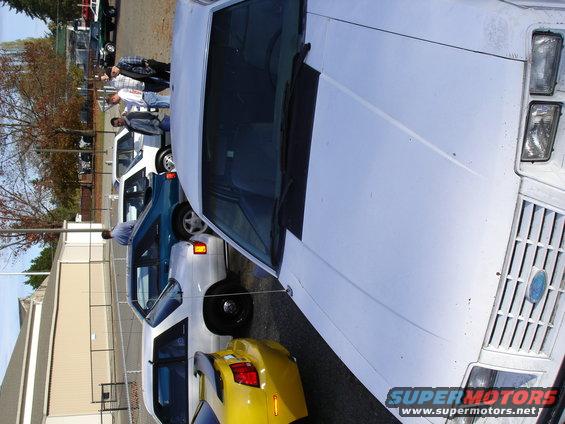 White Ford sedan, front view, grille visible, parked outdoors