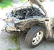 2004 Ford Taurus - The front of a silver 2004 Ford Taurus is shown with the hood open, revealing the engine and damage to the fender area.