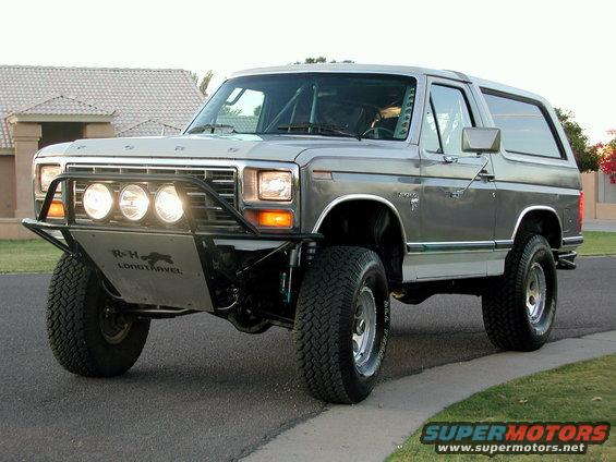 Silver 1980 Ford Bronco with off-road bumper and lights