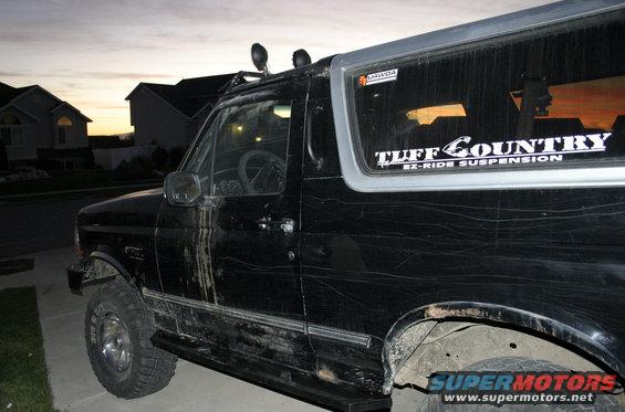 1994 Ford Bronco side view, black with "Tuff Country EZ-Ride Suspension" sticker on rear window