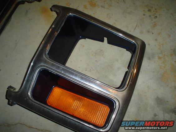 Chrome trim piece with an amber turn signal light, likely for a vehicle bumper