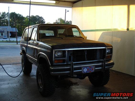 Dark blue Ford Bronco with lifted suspension and off-road tires, front view