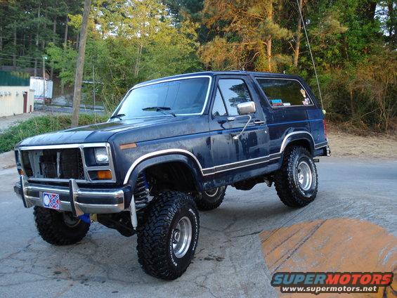 Dark blue lifted 1980 Ford Bronco with chrome trim and off-road tires