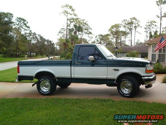 Two-tone green and white Ford F-150 pickup truck parked on a driveway