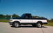 1995 Ford F-150 - This two-tone Ford F-150 pickup truck is shown from the side under a clear blue sky.
