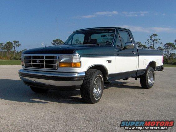 1995 Ford F-150 pickup truck, dark green and white two-tone paint, parked on asphalt