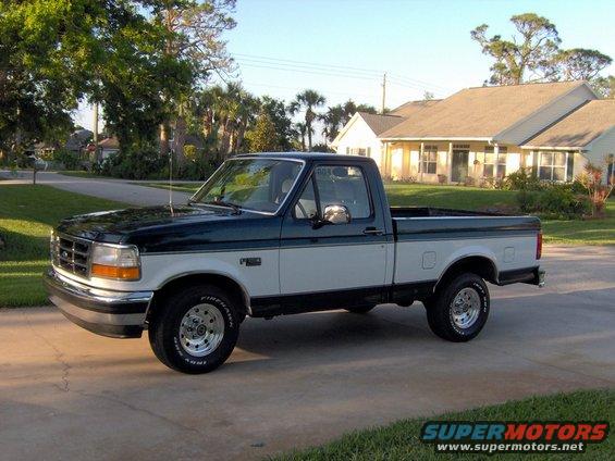 1995 Ford F-150 pickup truck, two-tone green and white paint, parked on a driveway