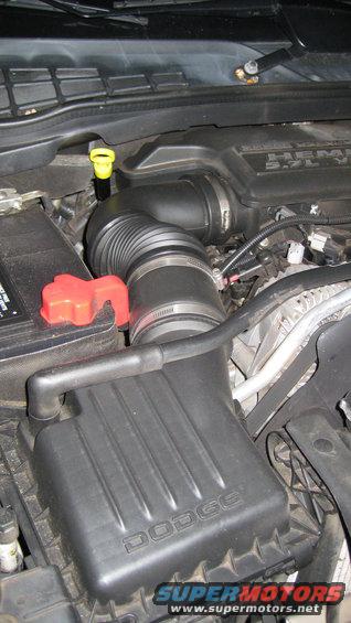 Dodge air intake system and battery in engine bay. Shows air filter box with 'DODGE' text