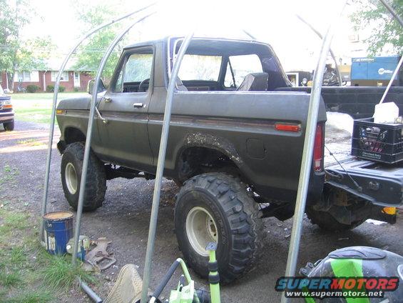1978 Ford Bronco parked under a carport with large off-road tires