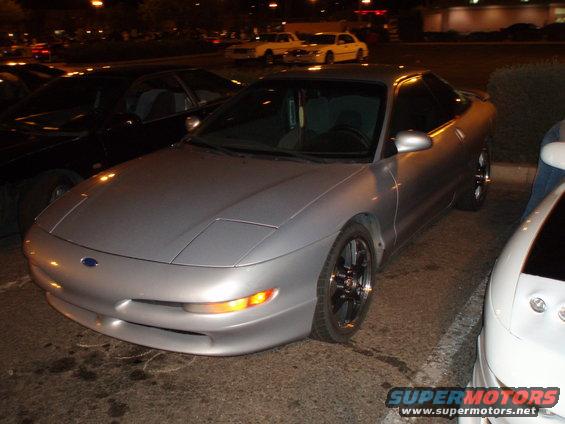 Silver 1997 Ford Probe parked at night, front quarter view. Another car is parked to the right