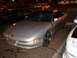 1997 Ford Probe - A silver 1997 Ford Probe is parked in a lot at night, showing its front end and side profile.