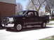 1994 Ford F-250 - This black pickup truck is shown from a 3/4 front angle. Its body style indicates it is likely a 2005-2007 model.