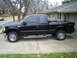1994 Ford F-250 - Side view of a black pickup truck with BFGoodrich tires. The body style suggests a model from the early 2000s.