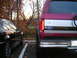 1994 Ford Bronco - Rear view of a 1994 Ford Bronco parked next to a black car in an autumn setting.