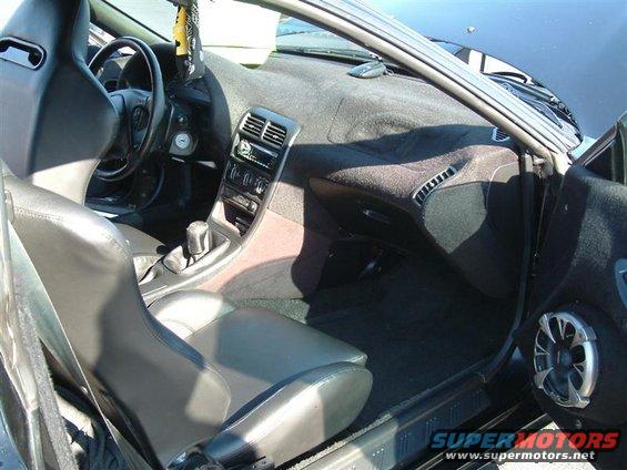 Interior of a car with bucket seats, dashboard, and center console. There's a 'Supermotors.net' watermark at the bottom right
