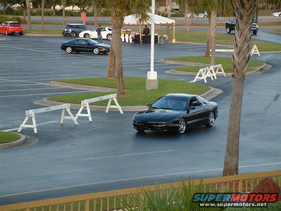 Black 1995 Ford Probe driving in a parking lot