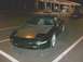 1995 Ford Probe - A dark-colored Ford Probe is parked at a gas station, with other vehicles in the background under the station lights.