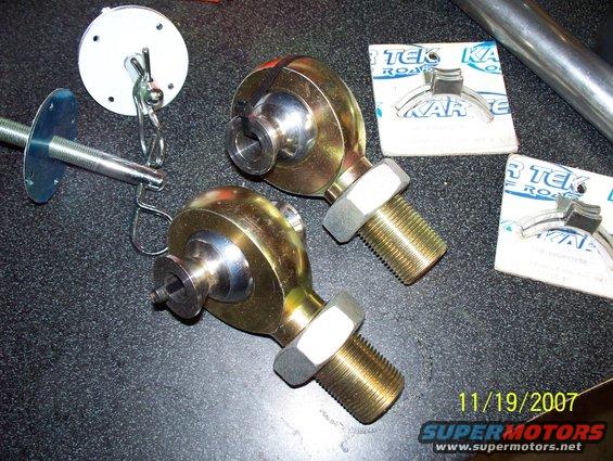 Two gold rod ends with threaded bolts and nuts, plus mounting hardware and packaging for KAR TEK ROAD