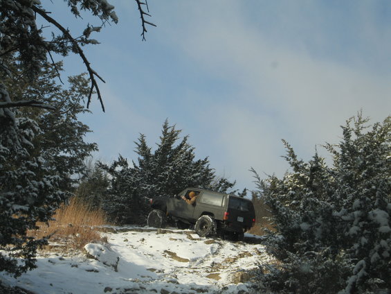 Dark 1995 Ford Bronco driving on snowy trail