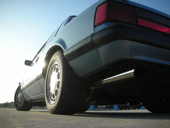 1990 Ford Mustang rear quarter panel, taillight, and exhaust pipe visible from a low angle