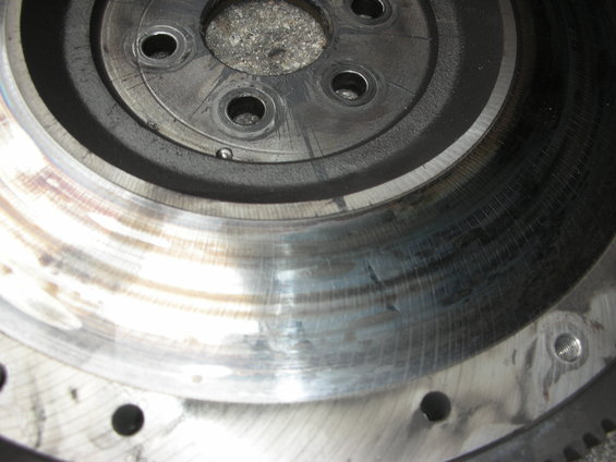 Close-up of a worn flywheel with scoring on the clutch surface