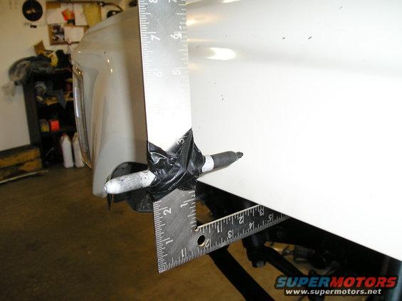 White fender with ruler and marker taped on