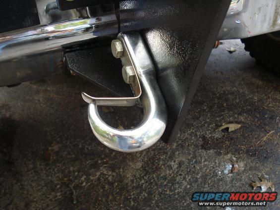 Chrome tow hook attached to black bumper bracket with two bolts