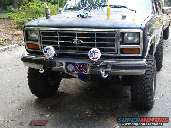 Front view of a dark blue Ford truck with KC lights and a Confederate flag plate