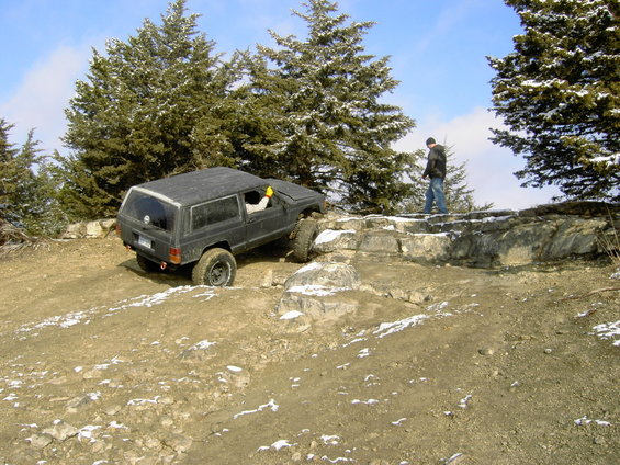 Black Jeep Cherokee XJ climbing rocky terrain