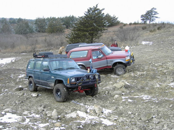 Red and gray 1995 Ford Bronco 3/4 front view on rocky terrain